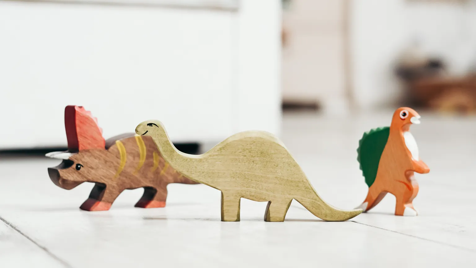 Ahşap zeminde renkli ahşap dinozor oyuncakları